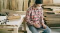 Handwerkerin mit Laptop in ihrer Werkstatt